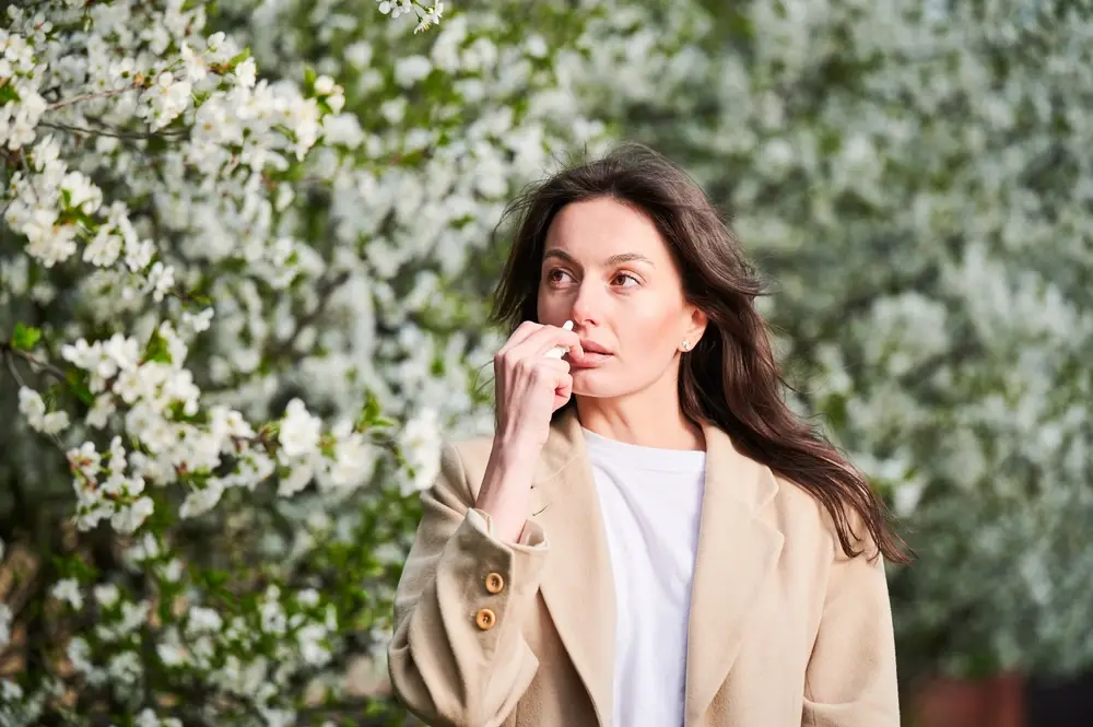 Woman with healthy skin outdoors among spring blossoms