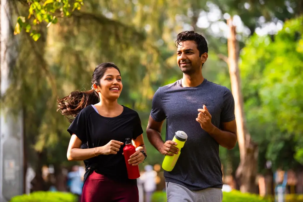 Active couple exercising outdoors with water bottles